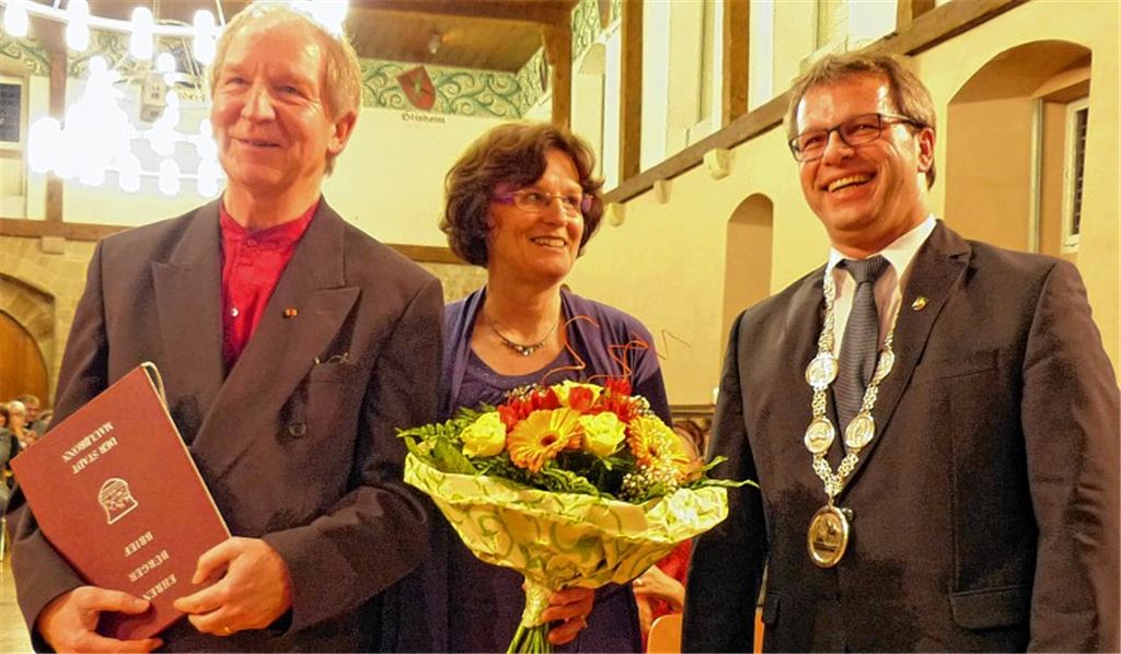 Für den Herrn die Ehrenbürger-Urkunde, für die Dame ein Blumengruß: Jürgen Budday, Erika Budday und Bürgermeister Andreas Felchle (re.) beim Empfang in der voll besetzten Stadthalle.