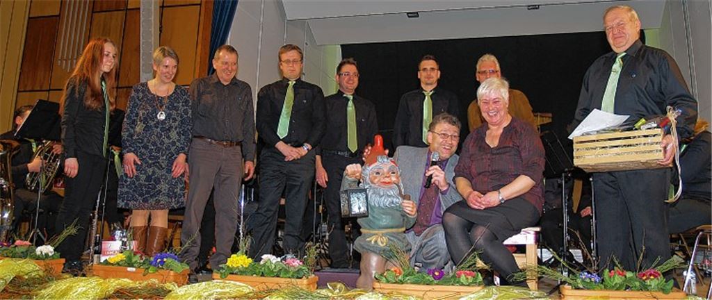 Für ihre ganz besonderen Verdienste bei der Herstellung von Mammutmengen an Kartoffelsalat erhält Brigitte Nonnenmann von Dirk Müller einen geschmückten „Thron“, einen Hocker, überreicht. Rechts Hornist Karl Hähnle, der für 50-jährige aktive Tätigkeit ausgezeichnet wird. Bild re.: Im Schlabberlook macht sich Simon Bechtold auf die Suche nach typisch deutschen Befindlichkeiten.