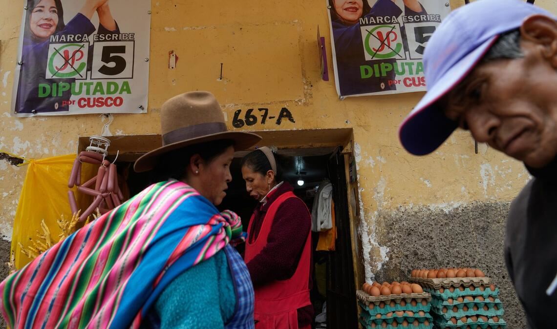 Fußgänger gehen an Wahlkampfplakaten in Cuzco in Peru vor den Präsidentschaftswahlen am Wochenende vorbei.