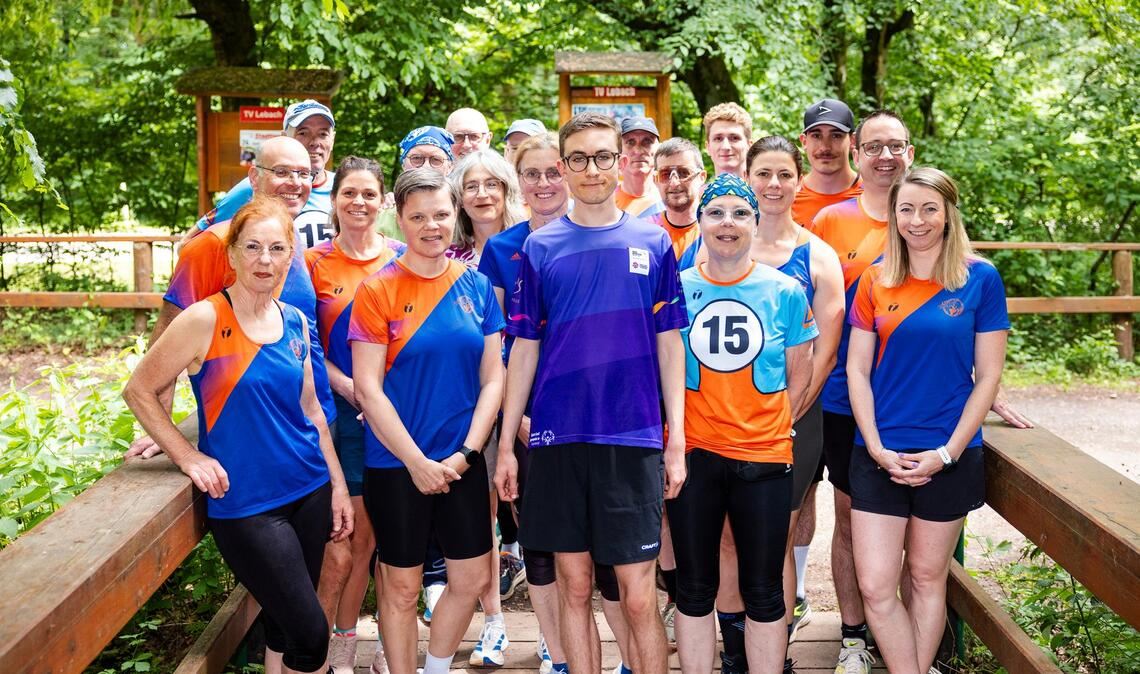 Fynn Thome (18, Mitte) posiert gemeinsam mit den Mitgliedern der Lauf- und Triathlonfreunde Lebach (LTF Theeltal) für ein Gruppenfoto.