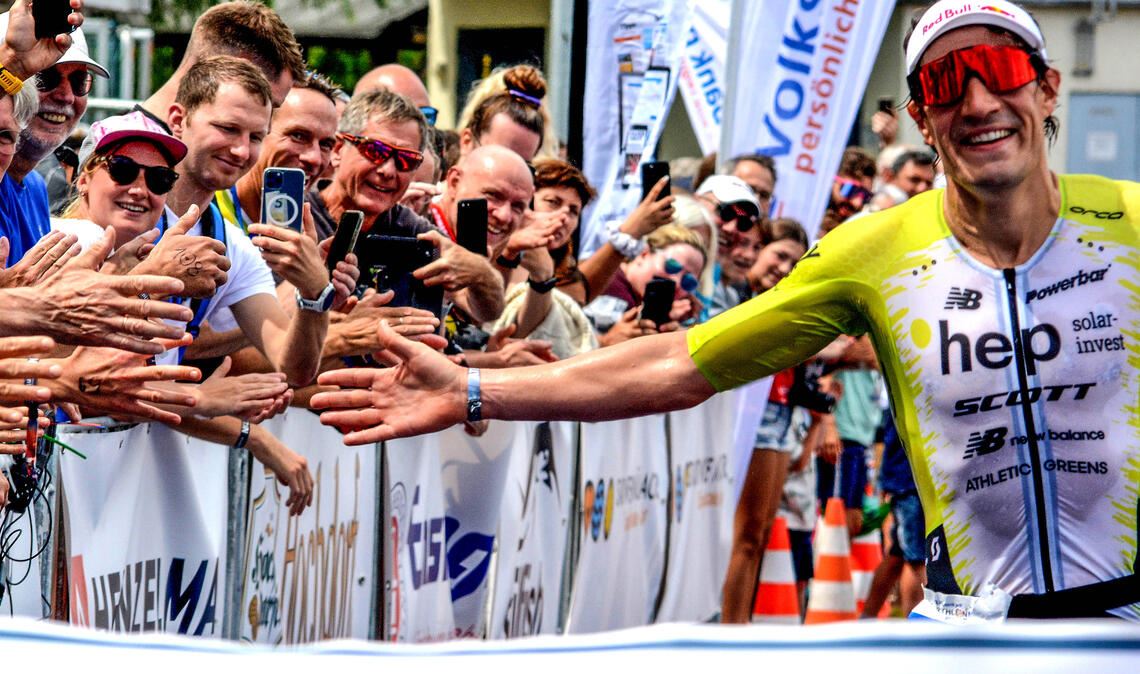 Gänsehautstimmung im Käppele-Stadion 2023: Sebastian Kienle wird von Hunderten Fans gefeiert als er als Sieger die Ziellinie überquert.