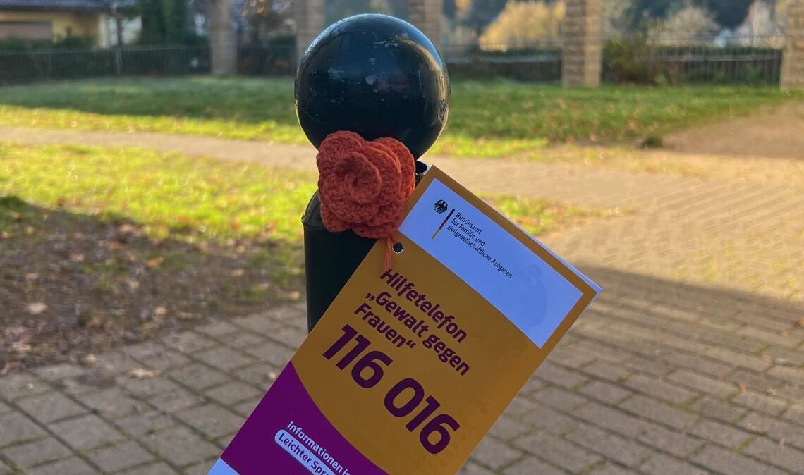 Gehäkelte Rosen mit Informationen zum bundesweiten Hilfetelefon 116016 werden an Pollern, Laternen, Bäumen und Masten in Ispringen angebracht. Foto: Enzkreis/Joos