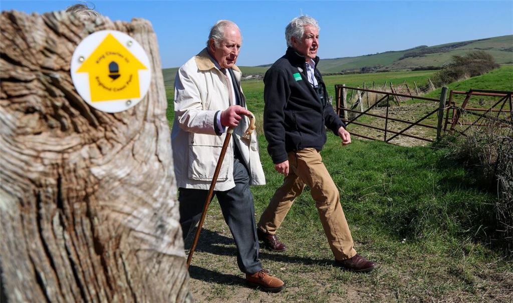 Gekleidet in Anzug und braunen Schuhen, wanderte der König gut zwei Kilometer an der Küste entlang.