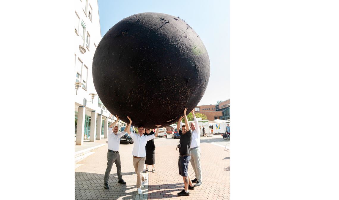 Schwarzer Spielball: Black Ball unterwegs in Mühlacker Gemeinsam lässt sich das Kunstobjekt anheben. Foto: Fotomoment