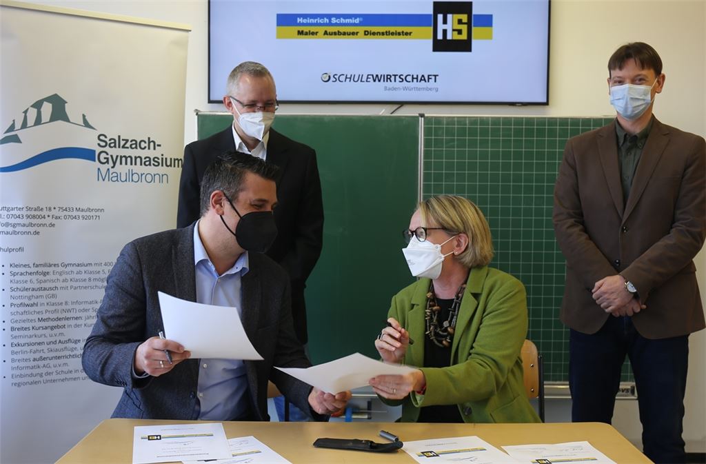 Gemeinsame Kooperation „Abi plus Gesellenbrief“ besiegelt: Für das Salzach-Gymnasium unterschreibt Rektorin Henriette Dieterle, für die Firma Heinrich Schmid Marc Fey. Mit dabei sind Thorsten Dörr, Berufs- und Studienberatungslehrer (hinten re.), sowie der für die Gewinnung von Azubis zuständige Firmenvertreter Björn Leyendecker. Foto: Disselhoff