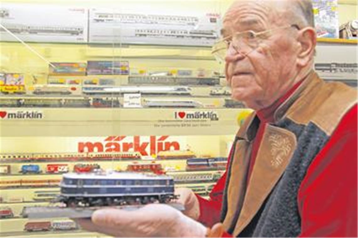 Gerhard Wolf, Seniorchef von Spielwaren-Heugel, präsentiert ein Märklin-Modell vor einem Schaukasten. Foto: Franz