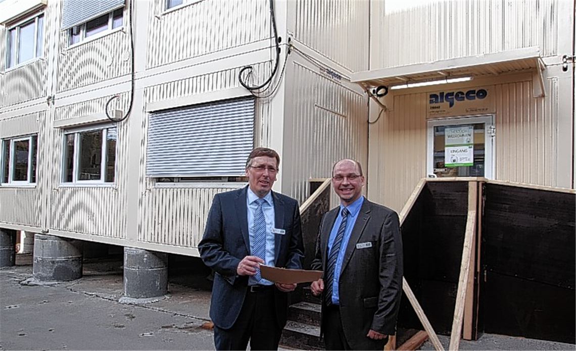 Geschäftsführer Hartmut Keller (li.) und der Mühlacker AOK-Chef Marcus Bischoff vor den Containern, die während des Gebäudeumbaus als Interimsunterkunft dienen. Fotos: Sadler