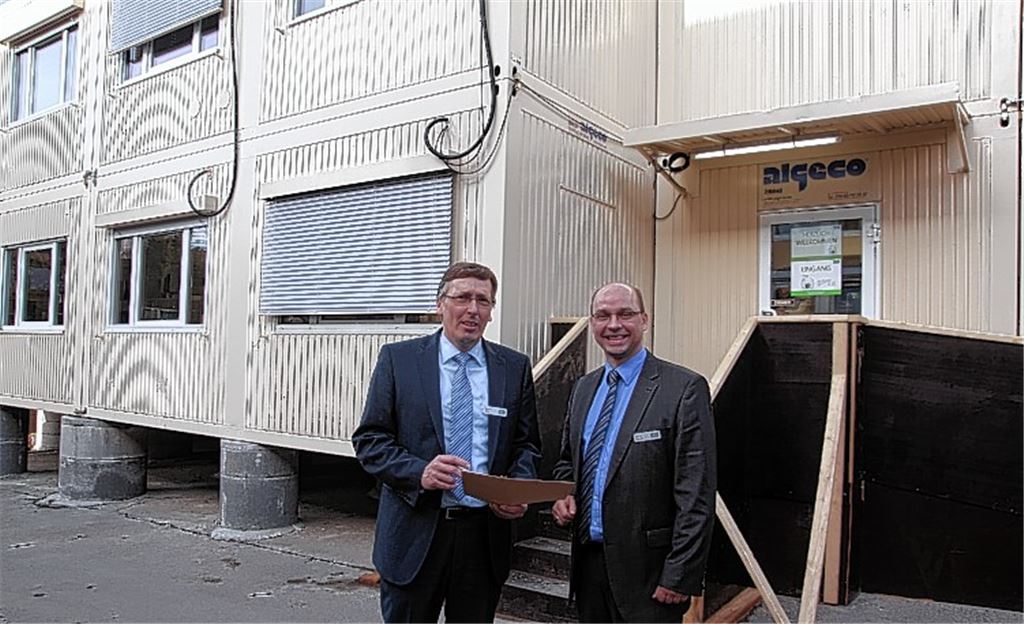 Geschäftsführer Hartmut Keller (li.) und der Mühlacker AOK-Chef Marcus Bischoff vor den Containern, die während des Gebäudeumbaus als Interimsunterkunft dienen. Fotos: Sadler
