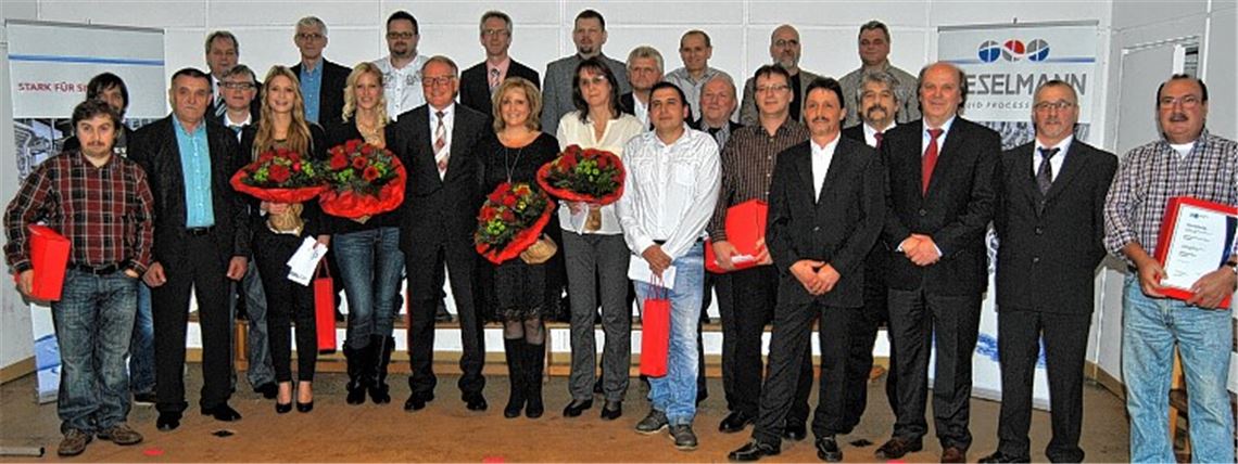 Geschäftsführer Klaus Dohle, zwischen den Damen in der vorderen Reihe, ehrt im Rahmen der Jahresfeier Beschäftigte der Knittlinger Armaturenfabrik Kieselmann GmbH für zehn- bis 45-jährige Betriebszugehörigkeit. Mit auf dem Foto sind die Vertreter des Betriebsrates. Foto: Haller