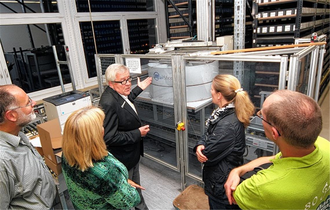 Geschäftsführer Klaus Wehmeyer zeigt den Gästen das robotergesteuerte Zentrallager.