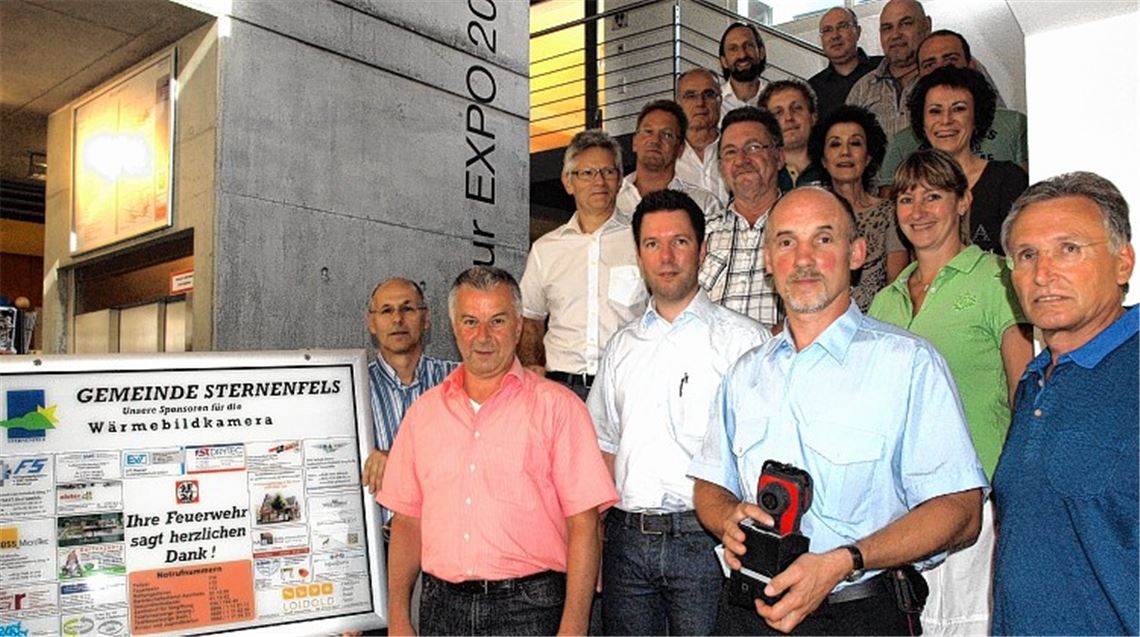 Gewerbetreibende und Bürgermeisterin Sigrid Hornauer übergeben der Feuerwehr Sternenfels eine Wärmebildkamera, mit der Glutnester aufgespürt werden können. Foto: Appich