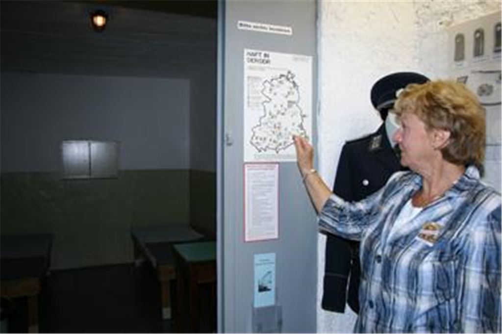 Gisela Lotz zeigt auf eine Karte, auf der alle Gefängnisse in der DDR eingezeichnet sind. 
Foto: Bettinger