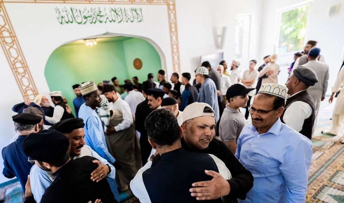 Gläubige umarmen sich bei den Feierlichkeiten zum Opferfest Eid al-Adha in der Khadija Moschee der Ahmadiyya-Muslim-Jamaat Berlin.
