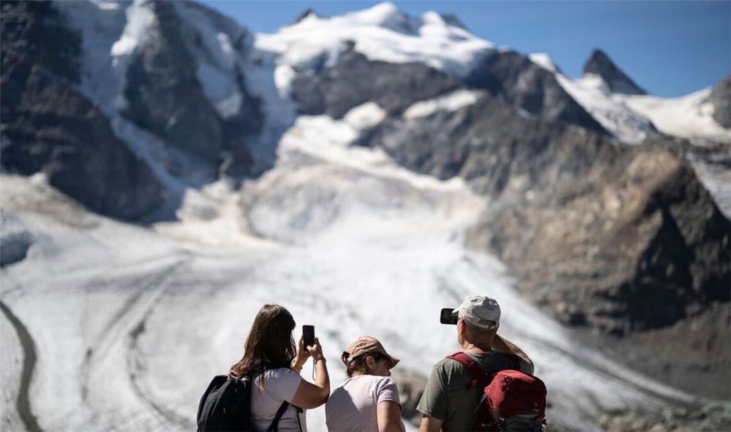 Gletscher in der Schweiz: Was auf den ersten Blick pittoresk wirkt - ein idyllischer Sommertag in den Alpen mit Touristen, die einen Gletscher fotografieren - ist in Wirklichkeit ein Warnsignal. Die Alpengletscher schmelzen immer schneller dahin.