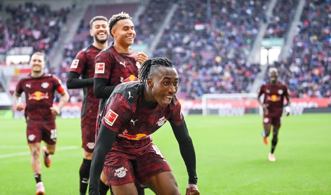Glückliche Leipziger, vorne 1:0-Schütze Yan Diomande, jubeln in Augsburg.