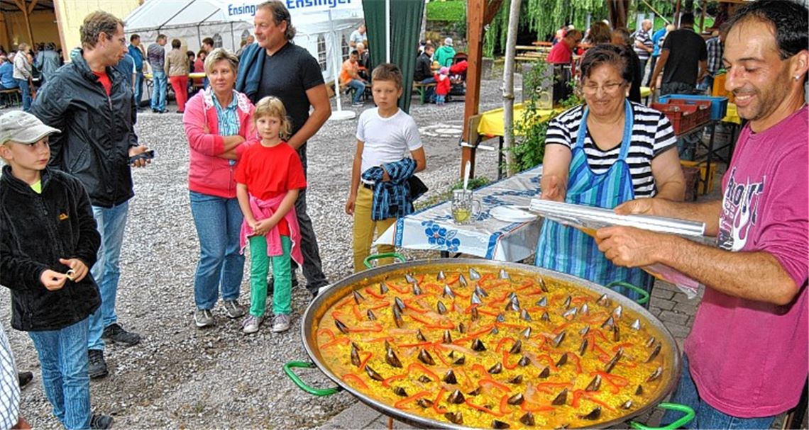 Großer Renner im Angebot ist die in der Riesenpfanne von Miguel Naranjo (re.) und Mutter Isabel zubereitete original spanische Paella. Die rund 120 Portionen sind im Nu vergriffen.Foto: Haller