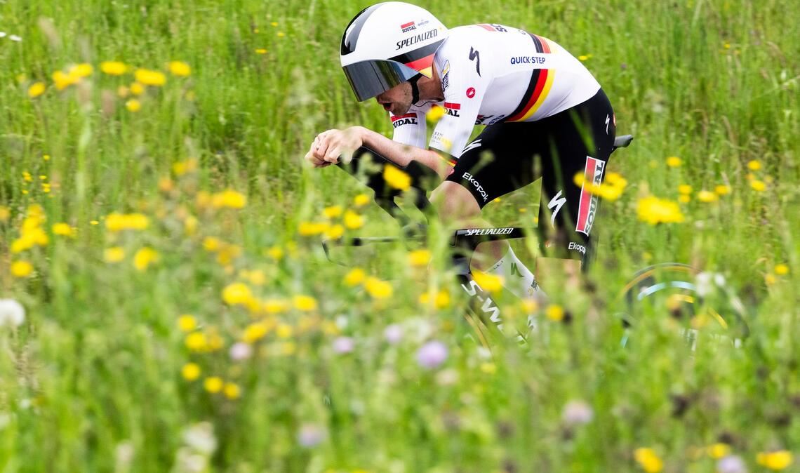Grüner Sport: Maximilian Schachmann aus Deutschland fährt bei der Tour de Romandie durch blühende Wiesen.