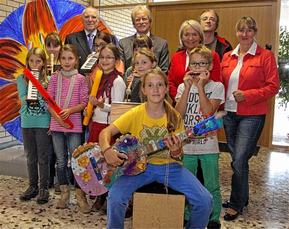 Grundschüler freuen sich über eine Spende des Rotary-Clubs für neue Musikinstrumente, die Karlheinz Schmid und Rotary-Präsident Jürgen Meeh (hinten v. li.) an Schulleiterin Christel Weigle-Mayer, Musiklehrer Stefan Fretz und Bürgermeisterin Sigrid Hornauer überreichen. Foto: Hansen