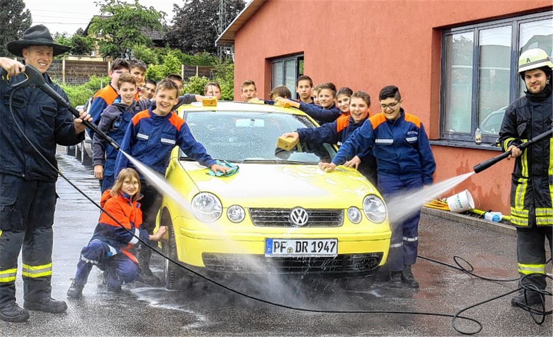 Gruppenfoto am Feuerwehrhaus: Gelber Kleinwagen wird zum Foto-Modell. Fotos: Hansen
