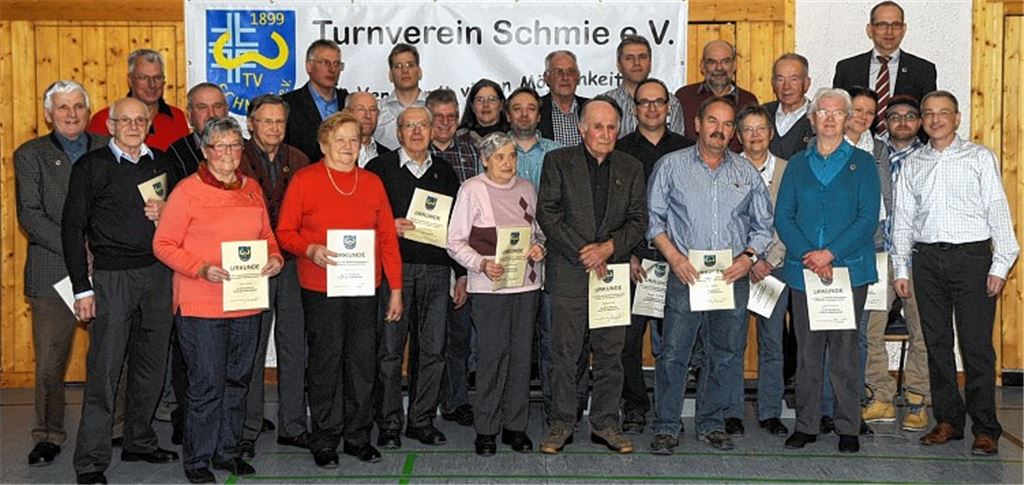 Gruppenfoto nach dem Ehrungsreigen in der Turn- und Festhalle: Der Vorsitzende des TV Schmie, Jürgen Link (hinten re.), zeichnet zahlreiche Mitglieder für ihre Vereinstreue aus. 