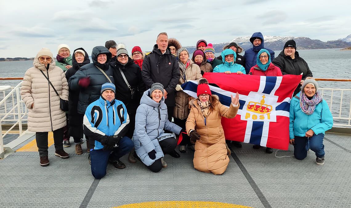 Gute Laune nach einem anstrengenden Auftakt zur Seereise: Gruppenbild auf dem Postschiff „Richard Witt“ mit der Fahne der Gastgeber. Fotos: Christina Wetzel