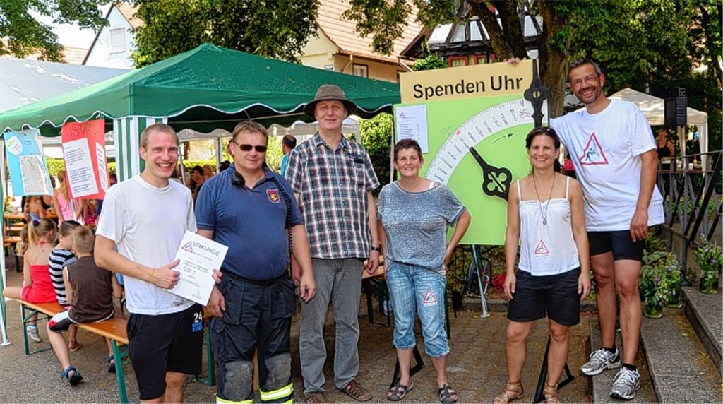 Gute Stimmung herrscht am Start und Ziel des Sponsorenlaufs (v. li.): Läufer Aaron Combe, Feuerwehrkommandant Jürgen Braun, Sponsor Peter Landgraf, die Ideengeber Kerstin Arnold und Andrea Stark und Kirchengemeinderat Stefan Huschitt von der Initiative „Turmretter“. 34000 Euro wurden zu Beginn der Aktion noch für die Sanierung benötigt, wie die Spenden-Uhr auswies.
