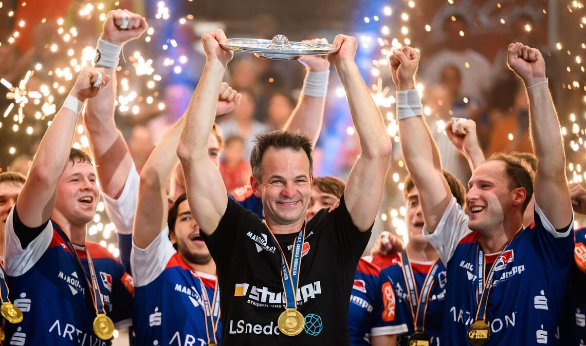 HBW-Coach Matthias Flohr präsentiert die Meisterschale.