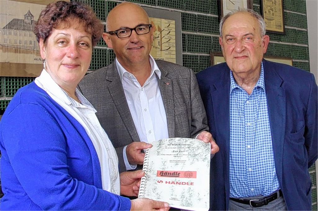 Händle-Geschäftsführer Gerhard Fischer überreicht Stadtarchivarin Marlis Lippik die von Willi Bender (re.) zusammengestellte Bilddokumentation.
