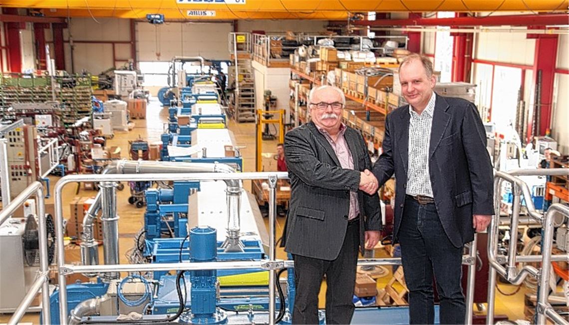 Handschlag nach Wechsel an der Spitze: der seitherige geschäftsführende Gesellschafter und Firmengründer Helmut Wahl (li.) und der neue Eigentümer von Extrudex, Christoph Scabell, in der Produktionshalle. Links hinter ihnen ist eine Extrusionsanlage zur Herstellung von Zahnbürstenborsten zu sehen. Abnehmer ist ein Kunde in Indonesien. Fotos: Sadler