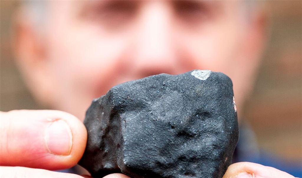 Hausbesitzer Wilfried Labusch mit einem kleinen Meteoriten, der niedergegangen ist.
