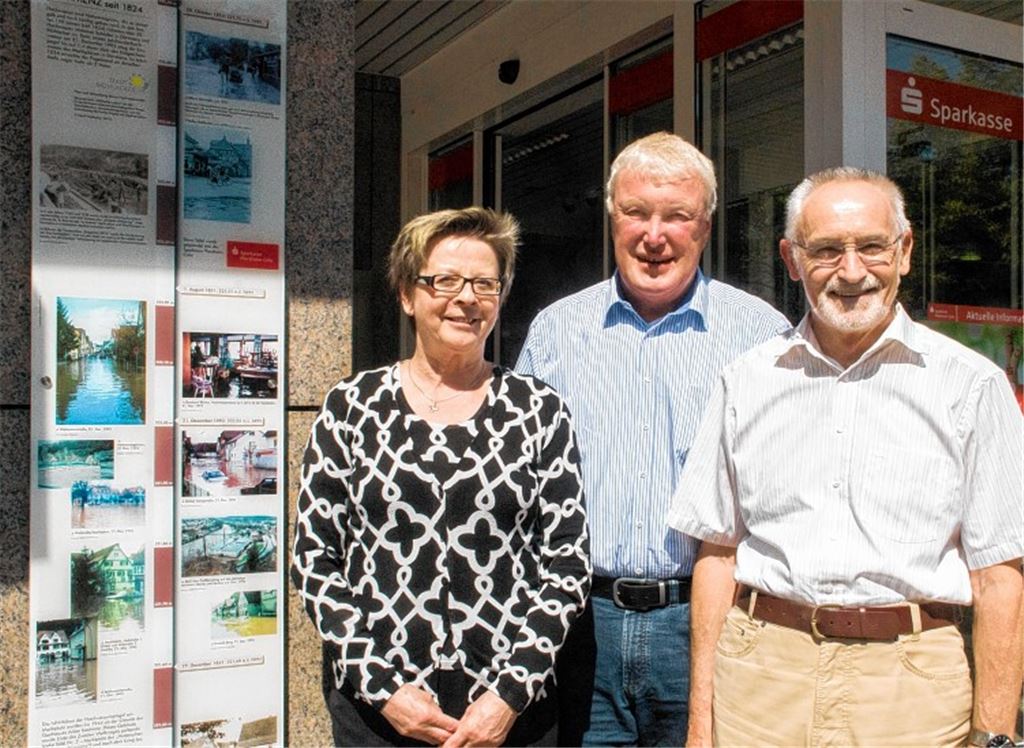 Hedwig Hammes von der Sparkasse und Bernd Wellinger und Ewald Scheytt (re.) vom Bürgerprojekt stellen die Hochwassertafel vor.