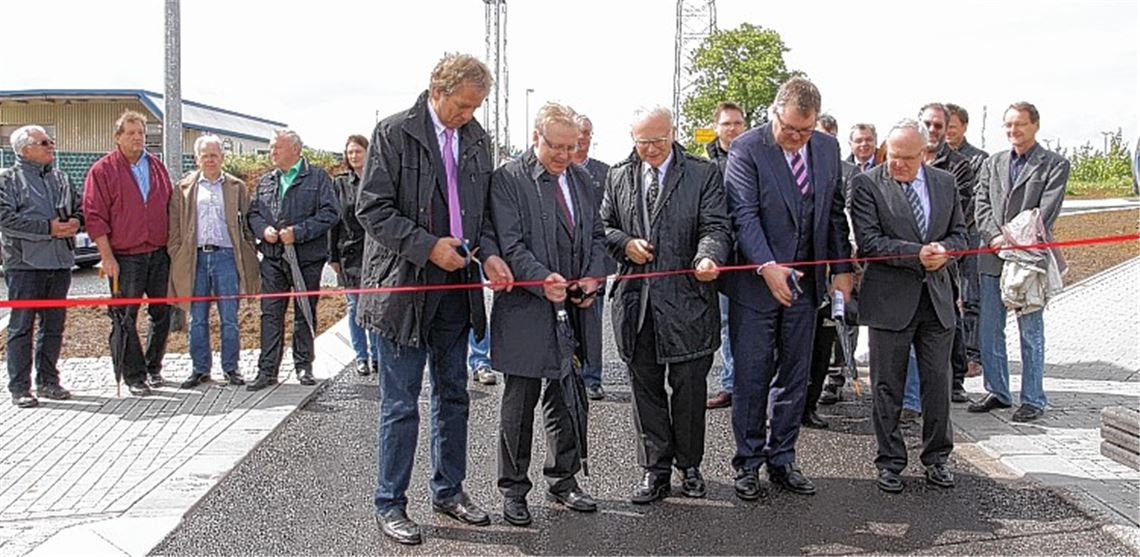 Heinz-Peter Hopp (li.), die drei Geschäftsführer der Firma Wolf, Jürgen Pfab (zweiter v. li.), Jürgen Steinbeck (zweiter v. re.), Siegfried Karst (re.) und Landrat Karl Röckinger eröffnen vor dem Knittlinger Gemeinderat den Kreisverkehr symbolisch mit einem Scherenschnitt.