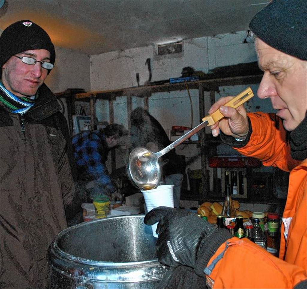 Heiß begehrt ist ein Becher wärmender Fleischbrühe an den Kontrollstellen. Wie man sieht, ist den Wanderern das Lächeln trotz der Minusgrade nicht vergangen. 