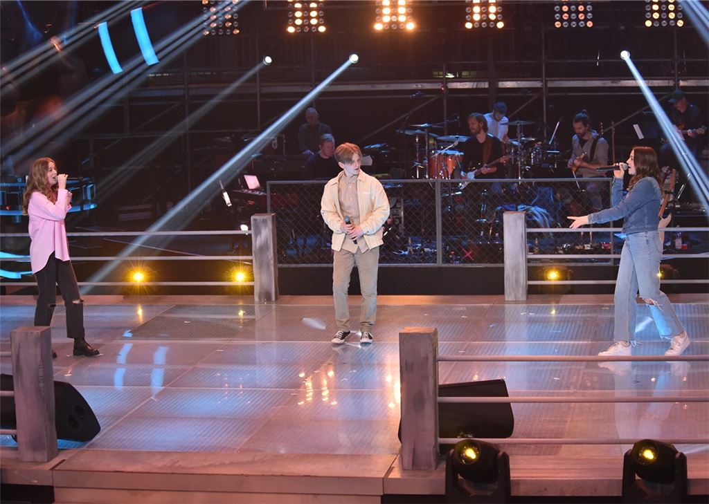Helena Hein-Talmon (li.) bei ihrem Battle-Auftritt bei der Jubiläumsstaffel von „The Voice Kids“ mit Marvin und Hannah. Foto: @SAT.1/Andre Kowalski.