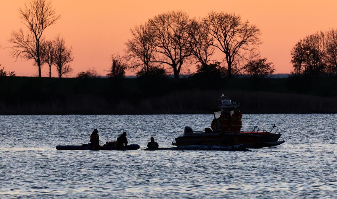 Helfer arbeiten in direkter Nähe des gestrandeten Wals vor der Insel Poel.