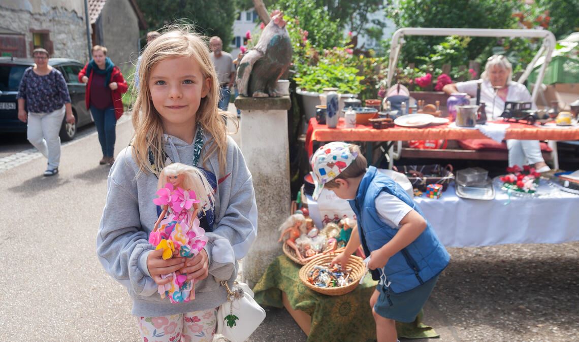 Hilda entdeckt am Stand von Christa Bohrer im Forellenweg ein Barbie-Puppe. „Sie hat ein schönes Gesicht und ein tolles Kleid an“, findet die Achtjährige. Mit ihren Eltern ist sie aus Schützingen nach Großglattbach gekommen. Foto: Fotomoment