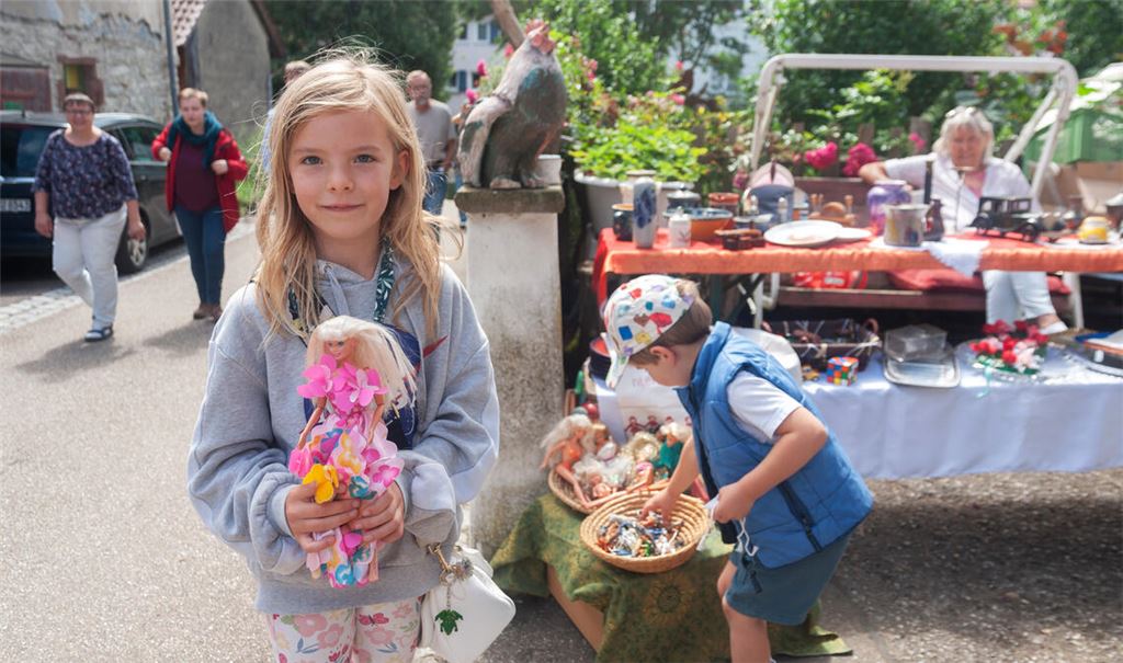Hilda entdeckt am Stand von Christa Bohrer im Forellenweg ein Barbie-Puppe. „Sie hat ein schönes Gesicht und ein tolles Kleid an“, findet die Achtjährige. Mit ihren Eltern ist sie aus Schützingen nach Großglattbach gekommen. Foto: Fotomoment