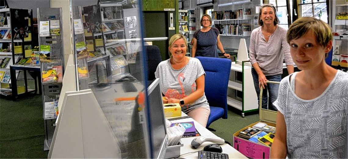 Hinter einer Scheibe sitzend, empfängt das Team der Stadtbibliothek mit Heidrun Fink (v.li.), Cornelia Kost, Claudia Heiler und Stephanie Gloß die Leserinnen und Leser.Stahlfeld