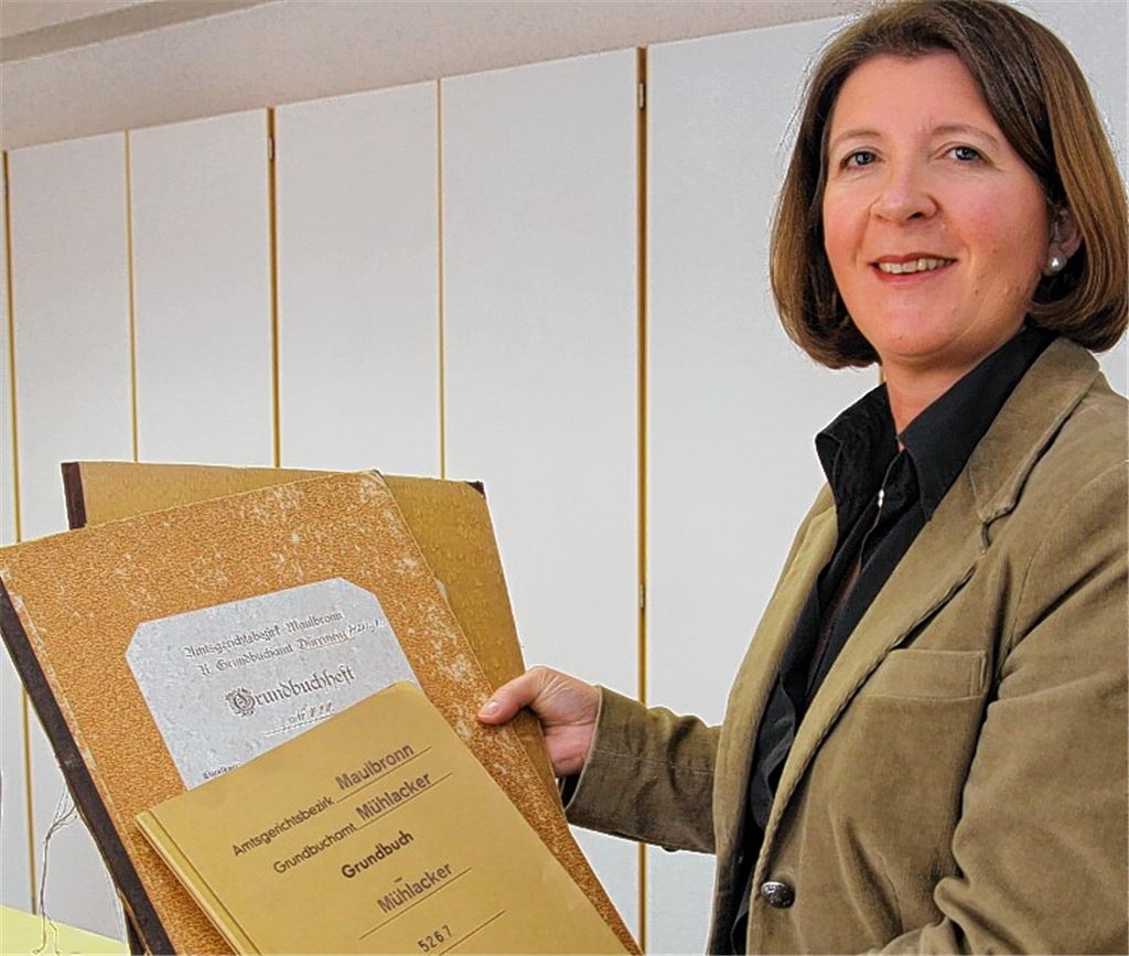 Historisch: Michaela Theilmann-Herbststreit mit alten Grundbüchern in Papierform.