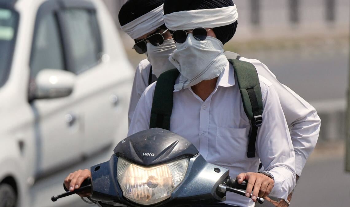 Hitze in Indien: Pendler schützen sich in Jammu vor der Sonne.