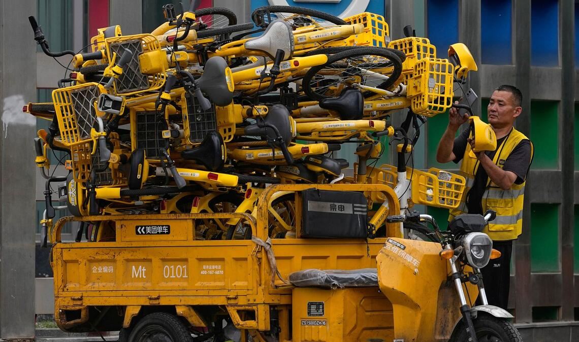 Hochstapler: Ein Arbeiter scannt Leihfahrräder auf seinem Transport-Dreirad in Peking.