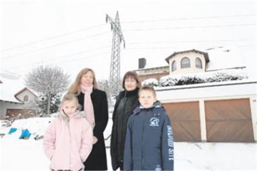 Hoffen auf eine Beseitigung des störenden Strommasts (v. li.): die betroffenen Nachbarn Anette Kummer mit Tochter Milena und Ulrike Zorn mit Sohn Michael. Foto: Tilo Keller