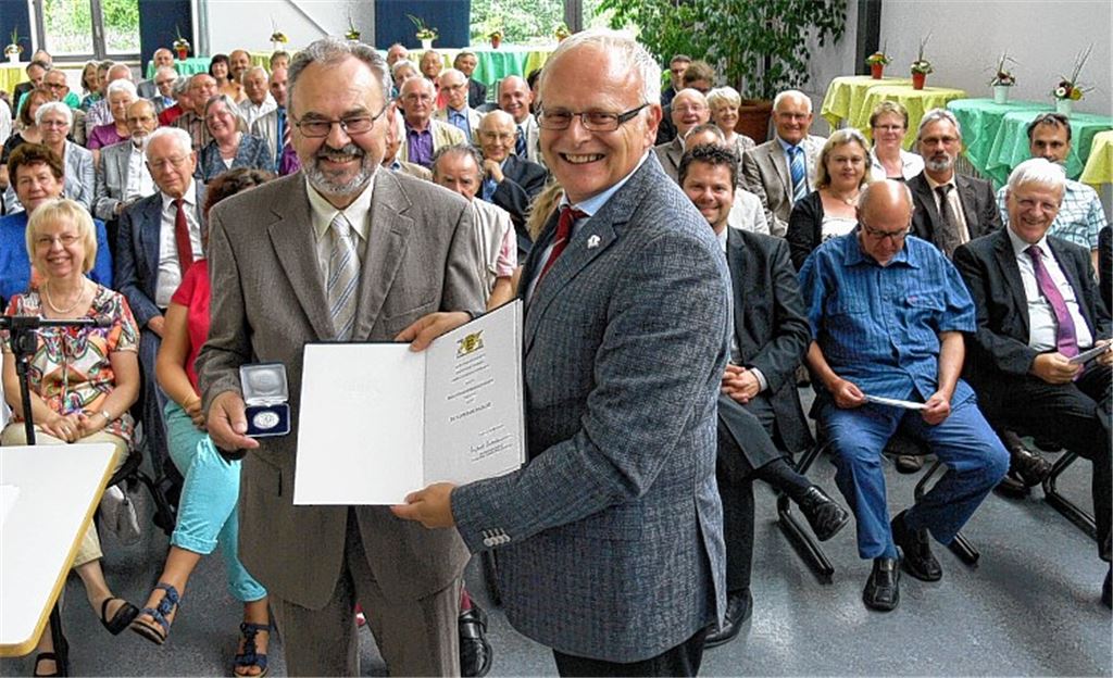 Hohe Auszeichnung für Gerhard Schollenberger: Landrat Karl Röckinger überreicht an den Sternenfelser die Stauffermedaille in Silber und die Urkunde des Ministerpräsidenten.