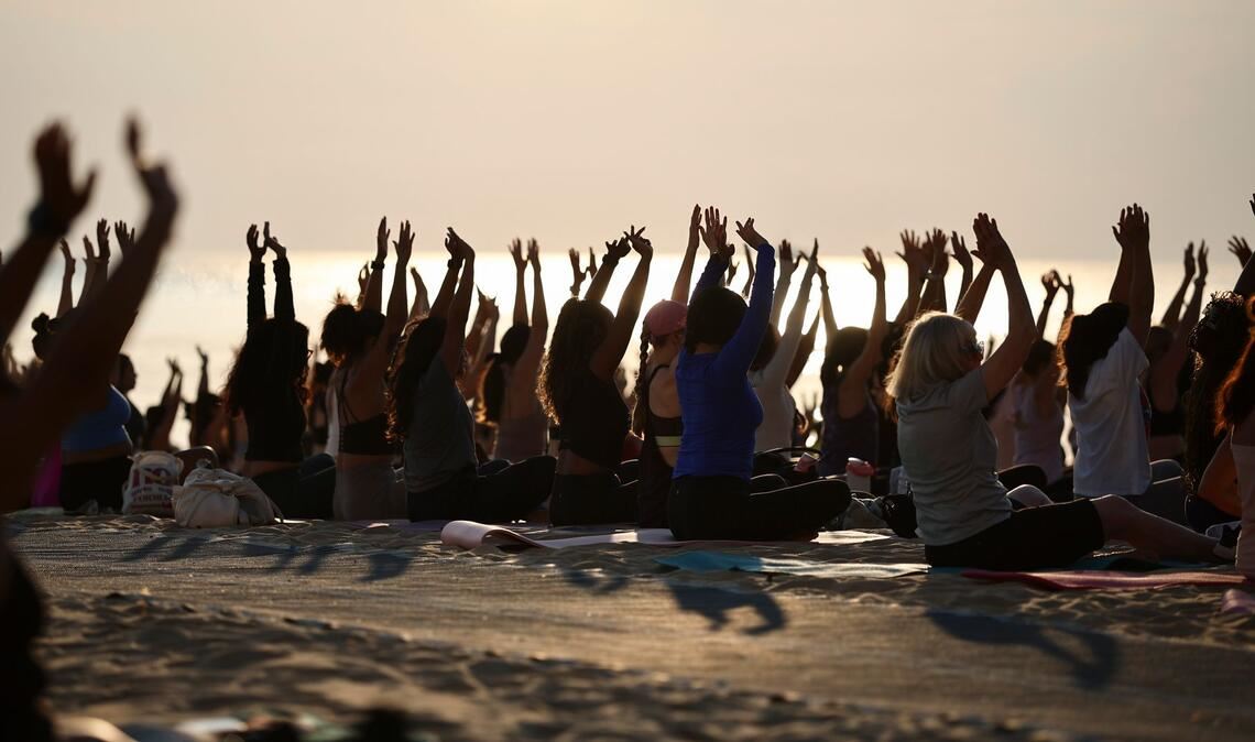 Hunderte Menschen nehmen an einer öffentlichen Yoga-Stunde am frühen Morgen am „Oak Street Beach“ am Lake Michigan teil.