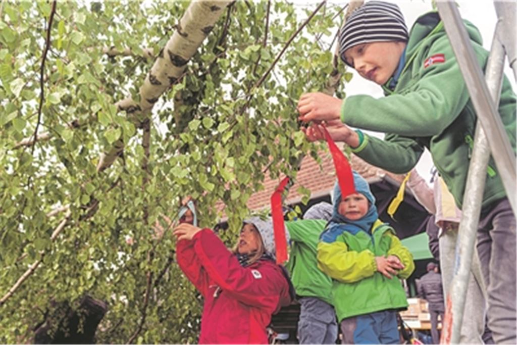Ida, Oskar und Hannes (v.li.) schmücken am Samstag den Maibaum in Lienzingen mit farbigen Bändern. Foto: Fotomoment