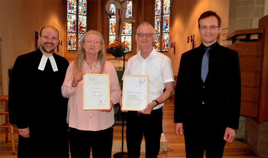 Illingens Pfarrer Tobias Wacker (li.) und Bezirkskantor Thorsten Hülsemann (re.) ehren Luise Lüttmann (stellvertretend für den Chor) und Chorleiter Siegfried Mangold.