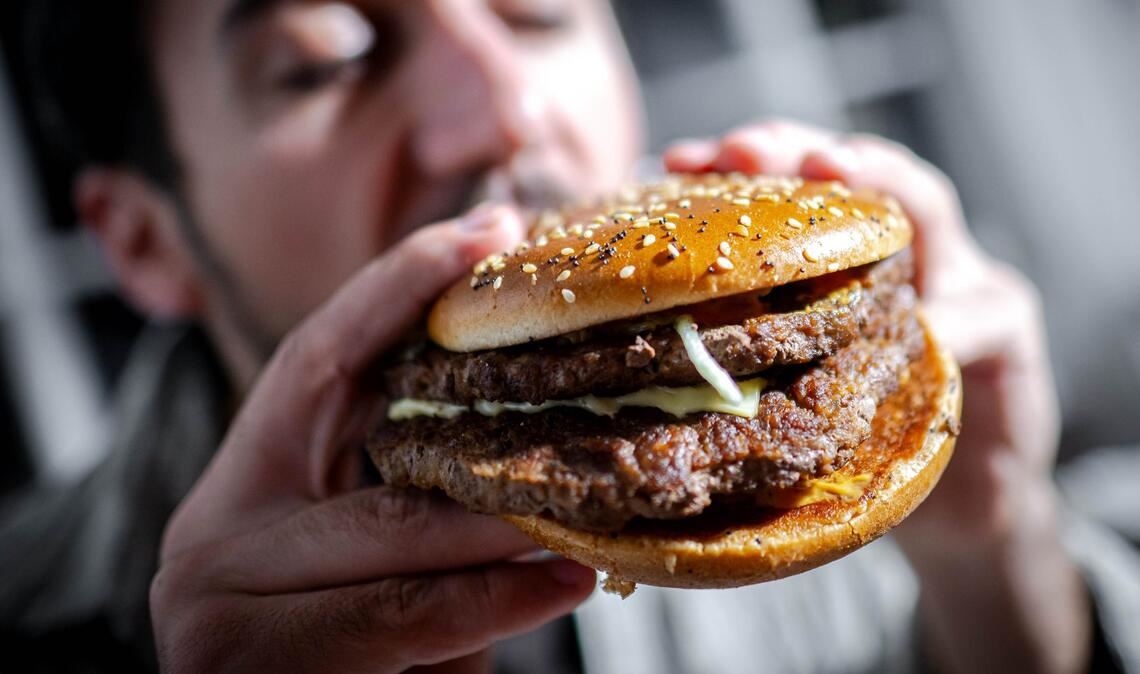 Illustration - Ein Mann beißt in einen Burger