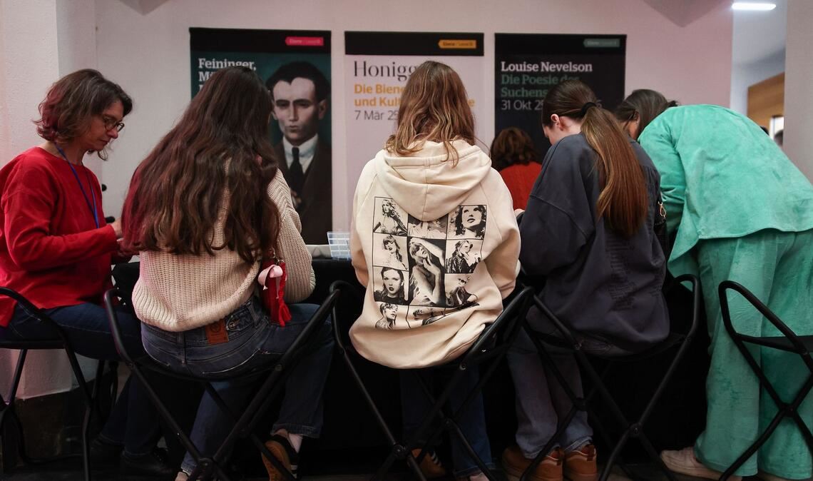 Im Foyer des Museums läuft Popmusik, während Fans Freundschaftsbändchen knüpfen.