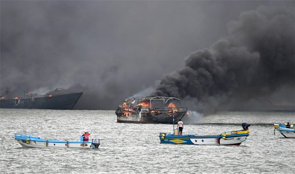 Im Hafen von Manta stehen mehrere Fischerboote in Flammen.