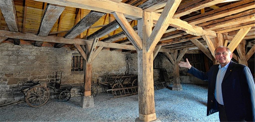 Im Schafhaus soll die neue Andachts- und Aussegnungshalle entstehen. Norbert Holme zeigt die zwei Holzpfeiler mit ihren Verstrebungen, die die Sicht auf das künftige Podium, das links entstehen soll, beeinträchtigen. Sie sollen durch schlankere Stahlstützen ersetzt werden.Foto: Martin Schott